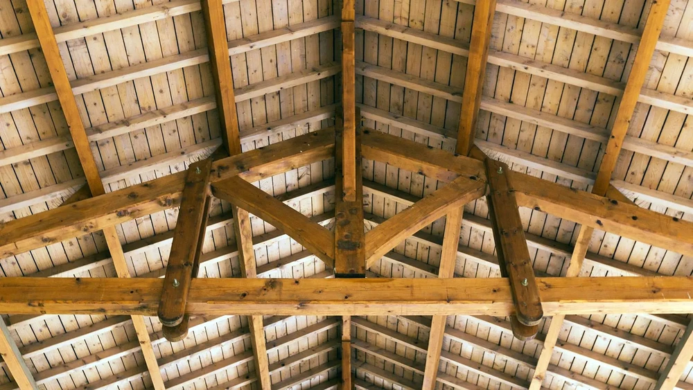 Intérieur d'une charpente traditionnelle en bois avec structure de toit apparente