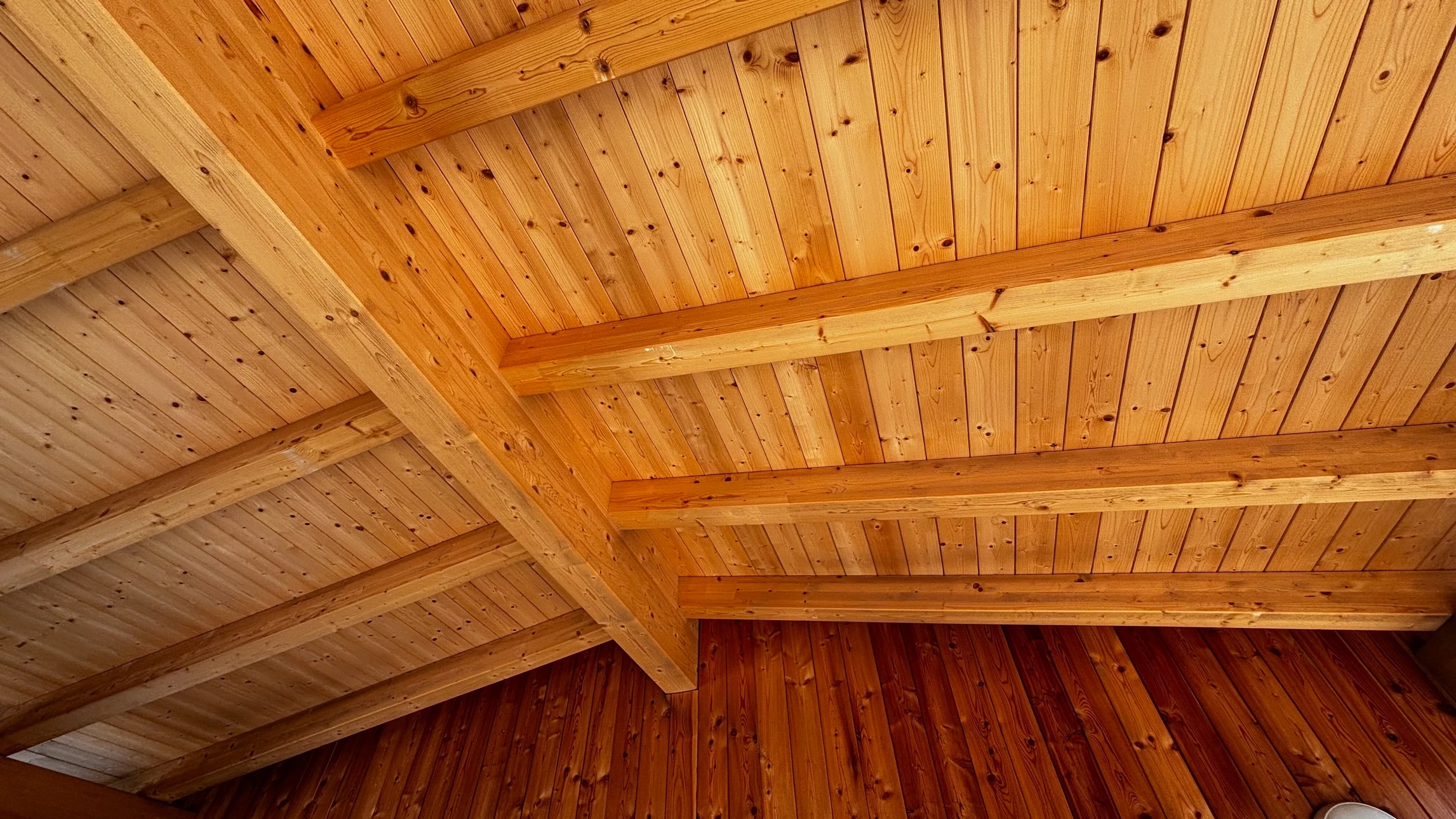 Atelier menuiserie intérieur avec deux artisans travaillant ensemble sur une pièce de bois